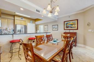 a dining room and kitchen with a table and chairs at Roomy beachfront condo with full kitchen shared pool and beach access in Fort Walton Beach