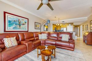 a living room with a brown leather couch at Roomy beachfront condo with full kitchen shared pool and beach access in Fort Walton Beach