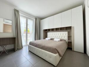a bedroom with a large bed and a large window at Relax Ligure in Boissano