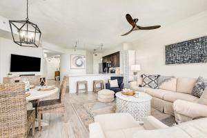 a living room with a couch and a table at Chic first-floor condo with Gulf & pool view & pickleball - steps to beach in Santa Rosa Beach