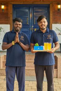 two men in blue shirts holding a tray of food at SaffronStays Anjee's Chalet in Dhamni +40 photos