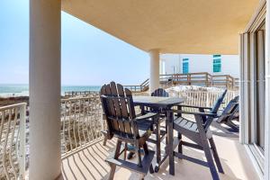 a balcony with a table and chairs and the ocean at Ground floor beachfront condo with shared pool and beach access in Santa Rosa Beach