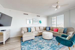 a living room with a couch and a tv at Ground floor beachfront condo with shared pool and beach access in Santa Rosa Beach