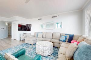 a living room with a couch and a table at Ground floor beachfront condo with shared pool and beach access in Santa Rosa Beach