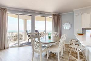 a kitchen and dining room with a table and chairs at Ground floor beachfront condo with shared pool and beach access in Santa Rosa Beach
