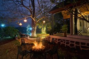 a fire pit in a backyard at night at SaffronStays Anjee's Chalet in Dhamni
