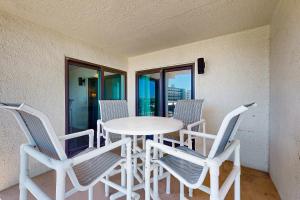a white table and chairs in a room with windows at Spacious home with balconies shared pool and beach access in Fort Walton Beach