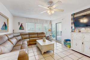 a living room with a couch and a ceiling fan at Spacious home with balconies shared pool and beach access in Fort Walton Beach