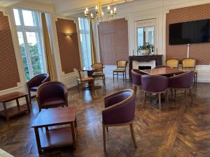 a room with tables and chairs and a fireplace at Château du Bourg in Saint-Denis-de-Gastines
