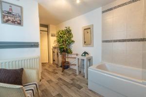 a bathroom with a tub and a chair and a table at 3 Bed in Appledore oc-cockle in Appledore +23 photos