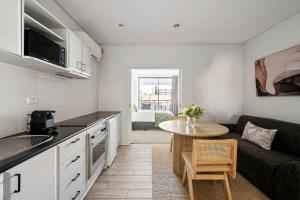 a kitchen and living room with a couch and a table at Walk Everywhere - Large Apartment & Sofa Bed in Perth