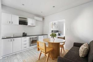 a kitchen and living room with a table and a couch at Walk Everywhere - Large Apartment & Sofa Bed in Perth