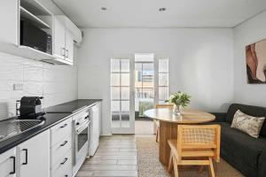 a kitchen and living room with a table and a couch at Walk Everywhere - Large Apartment & Sofa Bed in Perth