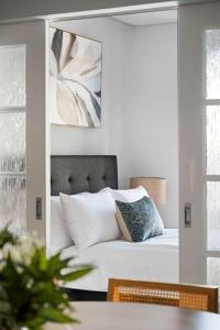 a bedroom with a bed with a mirror above it at Walk Everywhere - Large Apartment & Sofa Bed in Perth