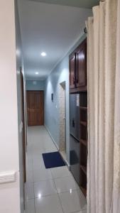 a hallway leading to a kitchen with a refrigerator at Home Soft in Douala