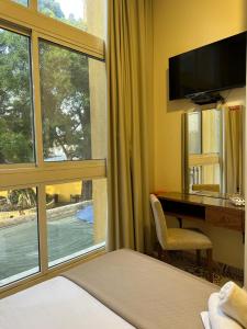 a hotel room with a desk and a window at Mar Mkhayel Studios in Beirut