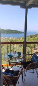 a glass table on a balcony with a view of the ocean at Skalopati Studios & Villa in Panormos Skopelos