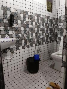 a bathroom with a toilet and a bucket at Pines pool homestay in Darjeeling