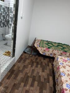 a room with two beds and a bathroom with a toilet at Pines pool homestay in Darjeeling