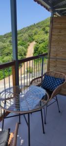 a table and chairs on a balcony with a view at Skalopati Studios & Villa in Panormos Skopelos +96 photos