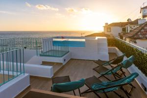 a balcony with chairs and a view of the ocean at Villa Belafonte in Câmara de Lobos