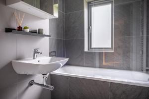 a bathroom with a sink and a tub and a window at 34 Ironworks in Backbarrow +26 photos
