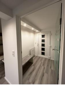 an empty room with a mirror and a hallway at Modernes Apartment nahe Frankfurt, Rodenbach & Hanau in Rodenbach
