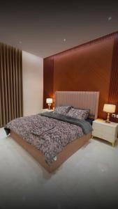 a bedroom with a large bed with a wooden headboard at ستارز هاوس in Najran