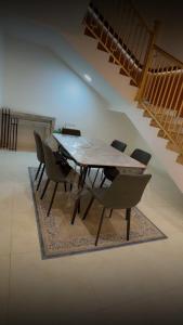 a dining table and chairs in a room with stairs at ستارز هاوس in Najran +22 photos