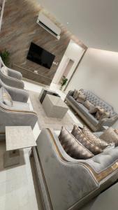 a living room with couches and a flat screen tv at ستارز هاوس in Najran