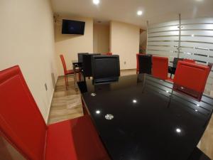 a conference room with red chairs and a television at H Boutique Touca in Toluca