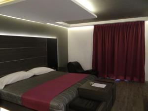 a bedroom with a bed and a red curtain at H Boutique Touca in Toluca