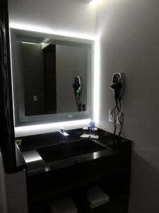 a bathroom with a black sink and a mirror at H Boutique Touca in Toluca