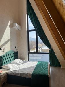 a bedroom with a bed and a large window at Luxury A-Frame Forest Chalet in Gabala +17 photos