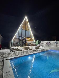 a swimming pool in front of a building at night at Luxury A-Frame Forest Chalet in Gabala