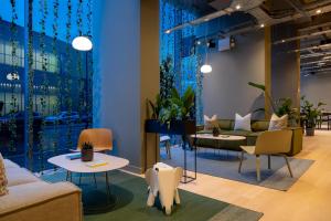 a waiting room with couches and tables and plants at Zedwell Hotel Greenwich in London