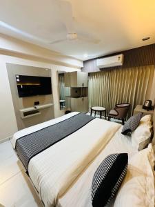 a hotel room with a large bed and a kitchen at Hotel M S Gold Ganadhinagar in Gandhinagar +19 photos