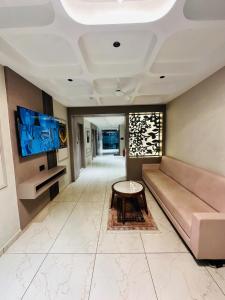 a living room with a couch and a table at Hotel M S Gold Ganadhinagar in Gandhinagar