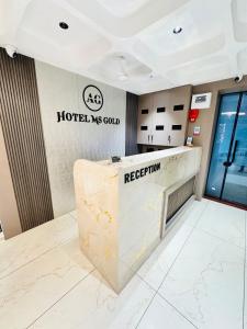 a hotel lobby with a reception counter and a reception desk at Hotel M S Gold Ganadhinagar in Gandhinagar