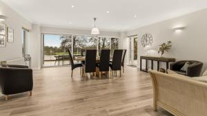 a dining room and living room with a table and chairs at The Nait in Fladbury