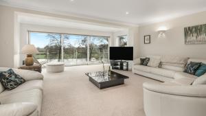 a living room with white furniture and a large window at The Nait in Fladbury