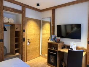 ein Zimmer mit Bett, Fernseher und Schreibtisch in der Unterkunft Hotel Grüner Baum in Würzburg