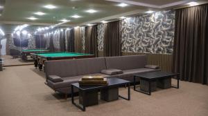 a living room with a couch and ping pong tables at Old Well Hotel in Tsaghkadzor