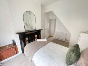 a bedroom with a bed with a fireplace and a mirror at 3 Bed plus Sofa sleeps 6 central in Middlesbrough