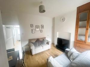 a living room with a white couch and a tv at 3 Bed plus Sofa sleeps 6 central in Middlesbrough