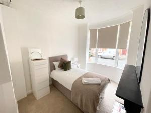 a white bedroom with a bed and a window at 3 Bed plus Sofa sleeps 6 central in Middlesbrough