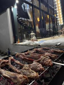 a bunch of meats are cooking on a grill at Luxury A-Frame Forest Chalet in Gabala