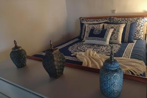 a bedroom with a bed with two vases on a table at Heritage House Malonas in Malona Village