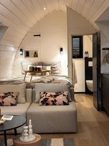 a room with two beds and a couch in a room at Simmerwille - stilte accommodaties in nationaal park de Alde Feanen in Earnewâld