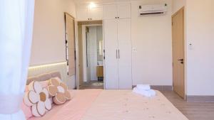 a bedroom with a bed with a pile of pillows at Bơ Home Novaworld in Phan Thiet